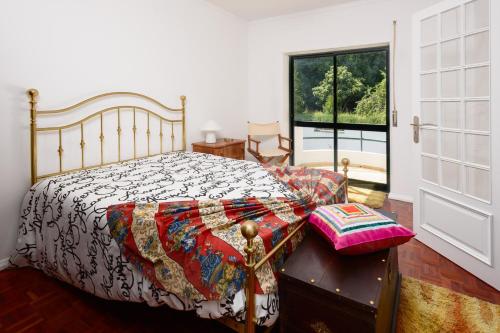 sypialnia z łóżkiem i dużym oknem w obiekcie Cister House w mieście Alcobaça