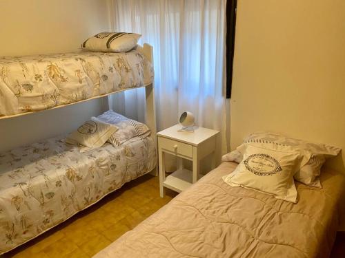 a bedroom with two bunk beds and a night stand at Departamento centrico in Trelew