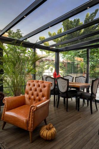 a conservatory with a couch and a table and chairs at Lagun Palas in Yalova