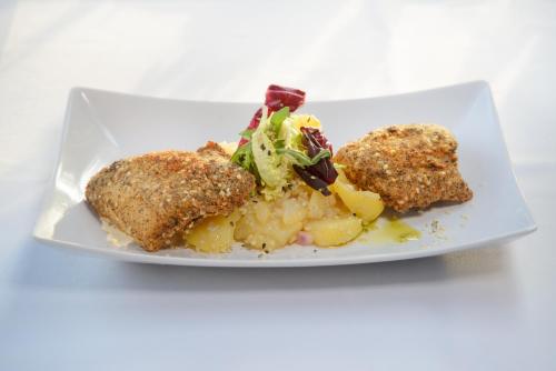 a white plate with two pieces of food on it at Wirtshausbrennerei Krenn in Yspertal