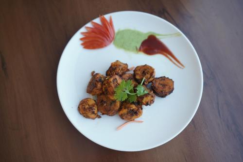 a white plate with food on a table at Hotel Idhayan Palace in Vrindāvan