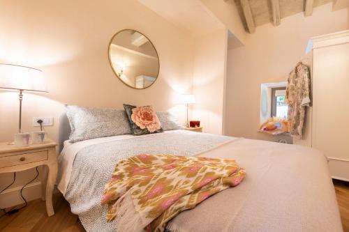 a bedroom with a large bed and a mirror at Isola Bella Apartments Via Vittorio Emanuele in Stresa