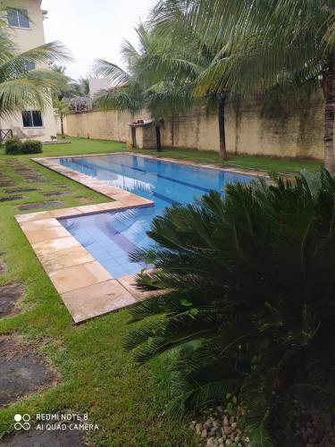 a swimming pool in a yard with palm trees at Apartamento Taiba Kite Beach Vista Mar in Taíba