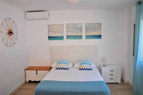 a bedroom with a bed with blue and white sheets at La Morada de Sebas in Málaga