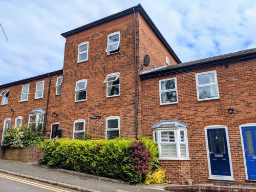 a red brick building with white windows and blue doors at Saffron Court by Wycombe Apartments - Apt 12 in High Wycombe
