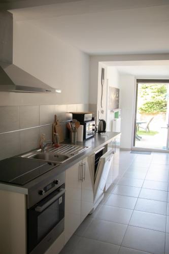 a kitchen with a sink and a stove at "Chez la Joe" in Thélonne