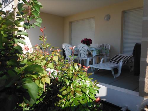 a patio with white chairs and a table and chairs at Résidence L'éléphant in Saint-Raphaël