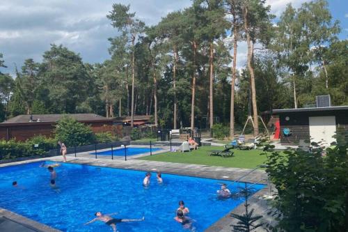 un groupe de personnes jouant dans une piscine dans l'établissement Luxe Veluwse Chalet te huur met sauna, à Doornspijk