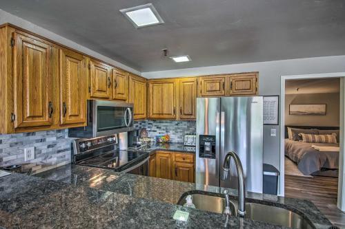 a kitchen with wooden cabinets and a stainless steel refrigerator at Pool Access Condo with Patio in Afton in Afton