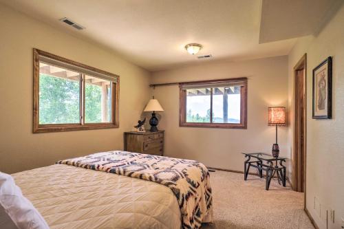 a bedroom with a bed and a table and two windows at Cripple Creek Mtn Getaway with Panoramic Views in Cripple Creek