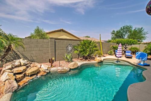 a swimming pool with a rock wall next to a swimming pool at Game Room, Fenced Yard Estrella Oasis in Goodyear in Liberty