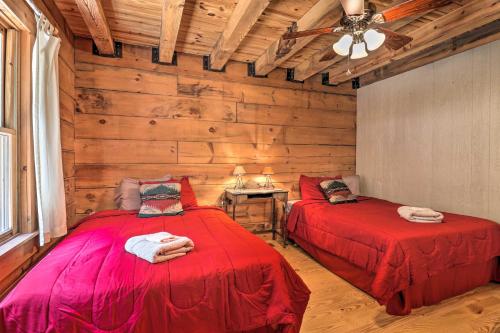 two beds in a room with wooden walls at Deck and Game Room Lakefront Landrum Cabin! in Landrum