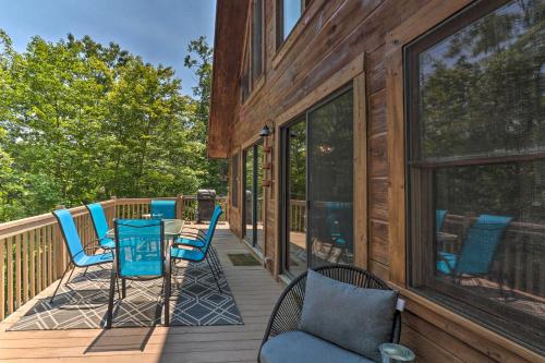 a deck with blue chairs and a table on a house at Deck and Game Room Lakefront Landrum Cabin! in Landrum