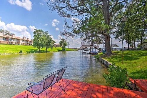 a bench sitting on a red platform next to a river at Cedar Creek Reservoir Home with Deck and Dock in Gun Barrel City