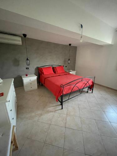 a bedroom with a bed with red sheets and red pillows at Casa Vacanze I Canarini in Città Giardino