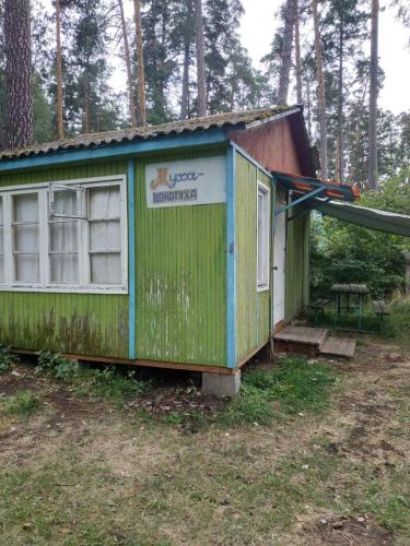 a small green house with a sign on it at База відпочинку Енергія in Rudnya Peskovskaya