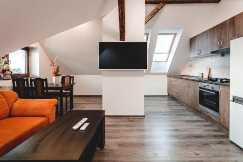 eine Küche und ein Wohnzimmer mit einem Sofa und einem Tisch in der Unterkunft Villa u Arény in Ostrava