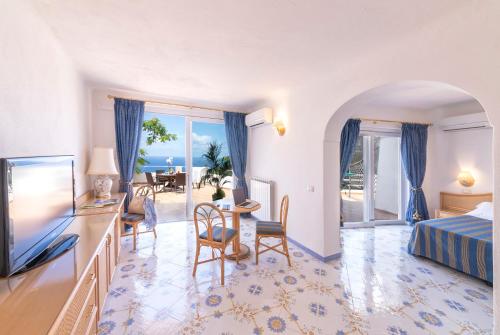 una habitación de hotel con una cama y un televisor en Hotel Grazia alla Scannella, en Isquia