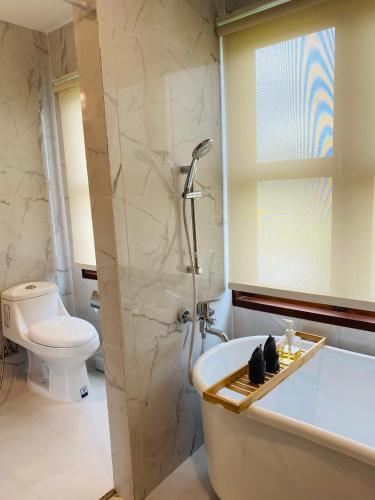 a bathroom with a tub and a shower and a toilet at Berghaus101khaoyai in Nakhon Ratchasima