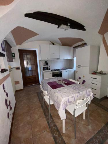 a kitchen with a table and chairs in a room at Orchidea in Carrù