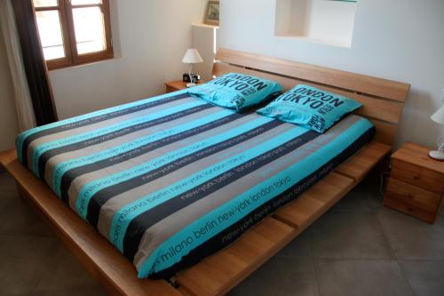 een bed met blauwe kussens in een kamer bij A la terrasse d'Avignon in Avignon
