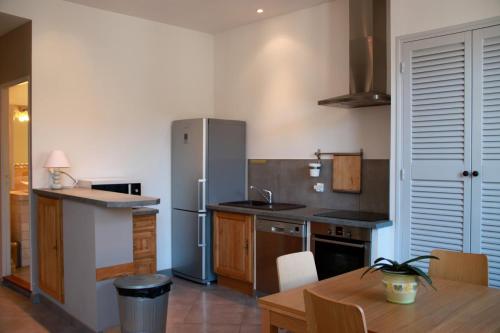 une cuisine avec un réfrigérateur en acier inoxydable et une table dans l'établissement A la terrasse d'Avignon, à Avignon