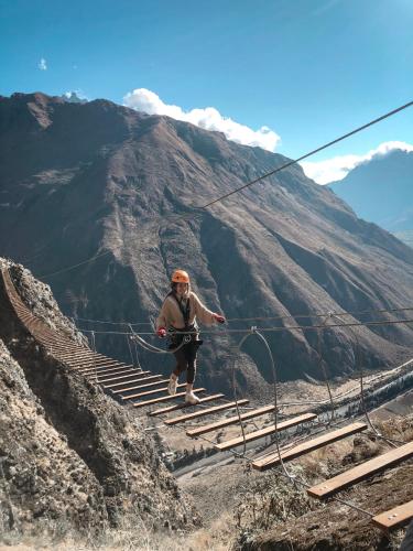 a man walking down stairs on a mountain at Vertical Sky Suites in Ollantaytambo