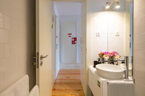 a bathroom with a white sink and a mirror at Douro Golden Studio in Porto