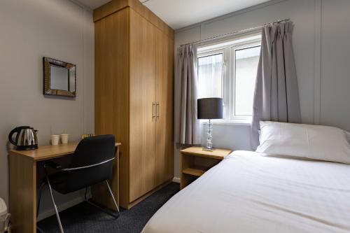 KirmingtonにあるNightel Hotelのベッド、デスク、窓が備わるホテルルームです。