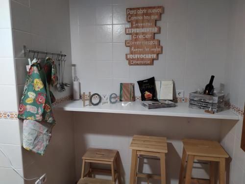 a counter with two stools and a shelf with a shelf at Playa, Golf y Montaña. Dos países, un lugar único. in Huelva