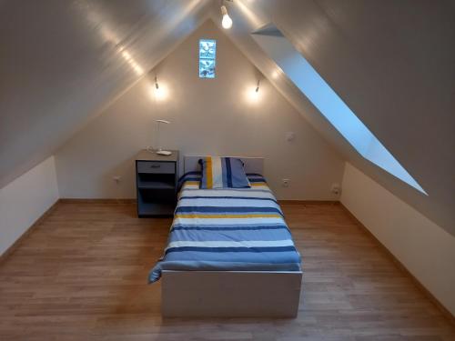 a attic bedroom with a bed and a window at Chez Jojo à St fraimbault in Saint-Fraimbault-de-Prières
