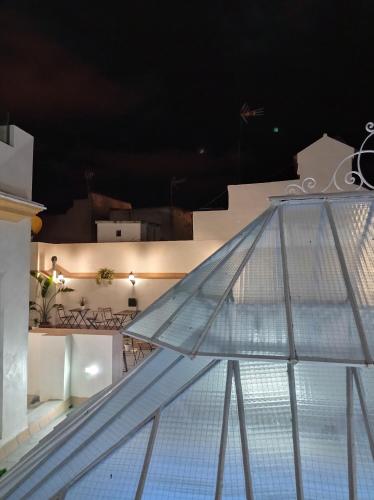 a glass railing on a balcony at night at Planeta Cadiz Hostel in Cádiz