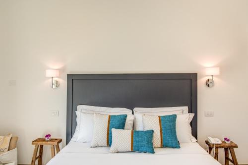 a bedroom with a large white bed with pillows at Cala Sinzias Resort in Castiadas