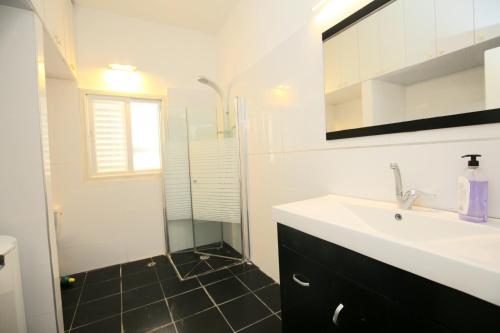 a bathroom with a sink and a shower at City center luxury apartment in Netanya in Netanya