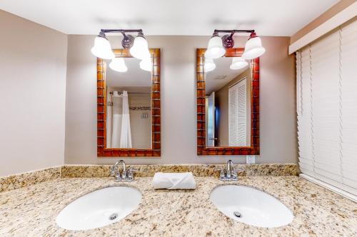 a bathroom with two sinks and two mirrors at Duck Key Bliss in Duck Key