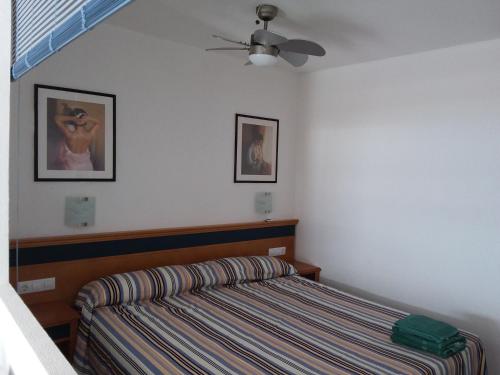 a bedroom with a bed and a ceiling fan at MIRAMAR ATTICO in Morro del Jable