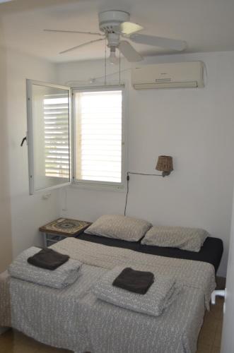a bedroom with two beds and a ceiling fan at Jerusalem 18 in Acre