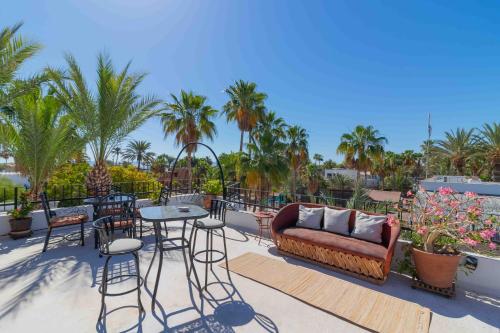 a patio with a couch and tables and chairs at Villas del Santo Niño in Loreto