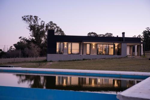 una casa con piscina frente a ella en Del Cerro Alquiler Temporario en Tandil