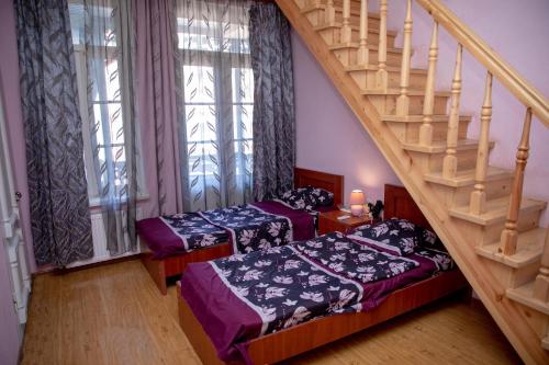 een kamer met 2 bedden en een trap bij DUPLEX in Tbilisi City