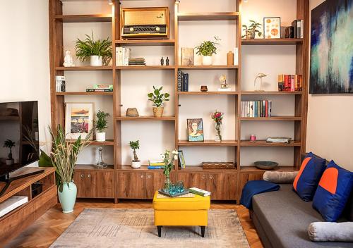 a living room with a couch and shelves with plants at Lovely Day in Gdynia