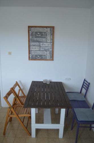 een houten tafel en stoelen in een kamer bij Jerusalem 18 in Akko