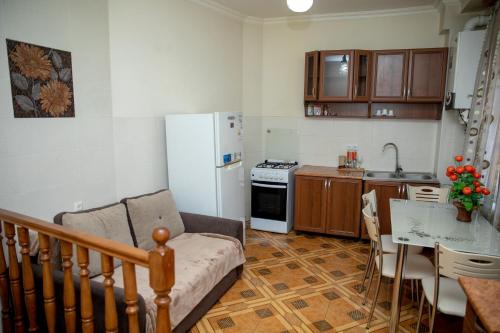 een keuken met een bank, een koelkast en een tafel bij DUPLEX in Tbilisi City