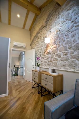 a living room with a stone wall at Borelli Palace & Borelli Blue in Zadar