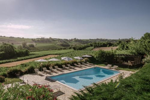 einen Pool mit Stühlen und Sonnenschirmen in der Unterkunft Agriturismo Bricco San Giovanni in Isola d'Asti