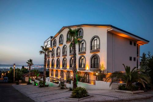 a large white building with palm trees in front of it at LAGUN CASTLE HOTEL&SPA in Yalova