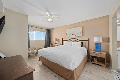 a bedroom with a bed and a desk and a window at The Summit 1011 in Panama City Beach