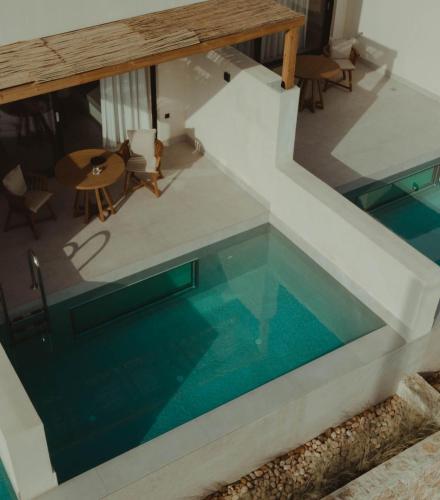 a house with a swimming pool with a staircase and a table at Seven Rocks in Paliouri