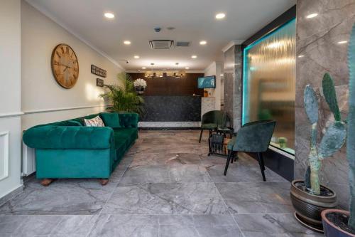 a living room with a couch and a clock on the wall at LAGUN CASTLE HOTEL&SPA in Yalova