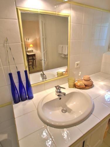 une salle de bain blanche avec un lavabo et un miroir dans l'établissement Domaine la Carraire, à Lauris